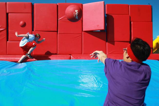 A volunteer throws balls at a participant as they make their way across an obstacle during the Hit and Run 5k Saturday, March 1, 2014 at Sam Boyd Stadium. The Hit and Run 5k, a fun run with various obstacles to navigate, is being held or planned in two dozen cities across the country.
